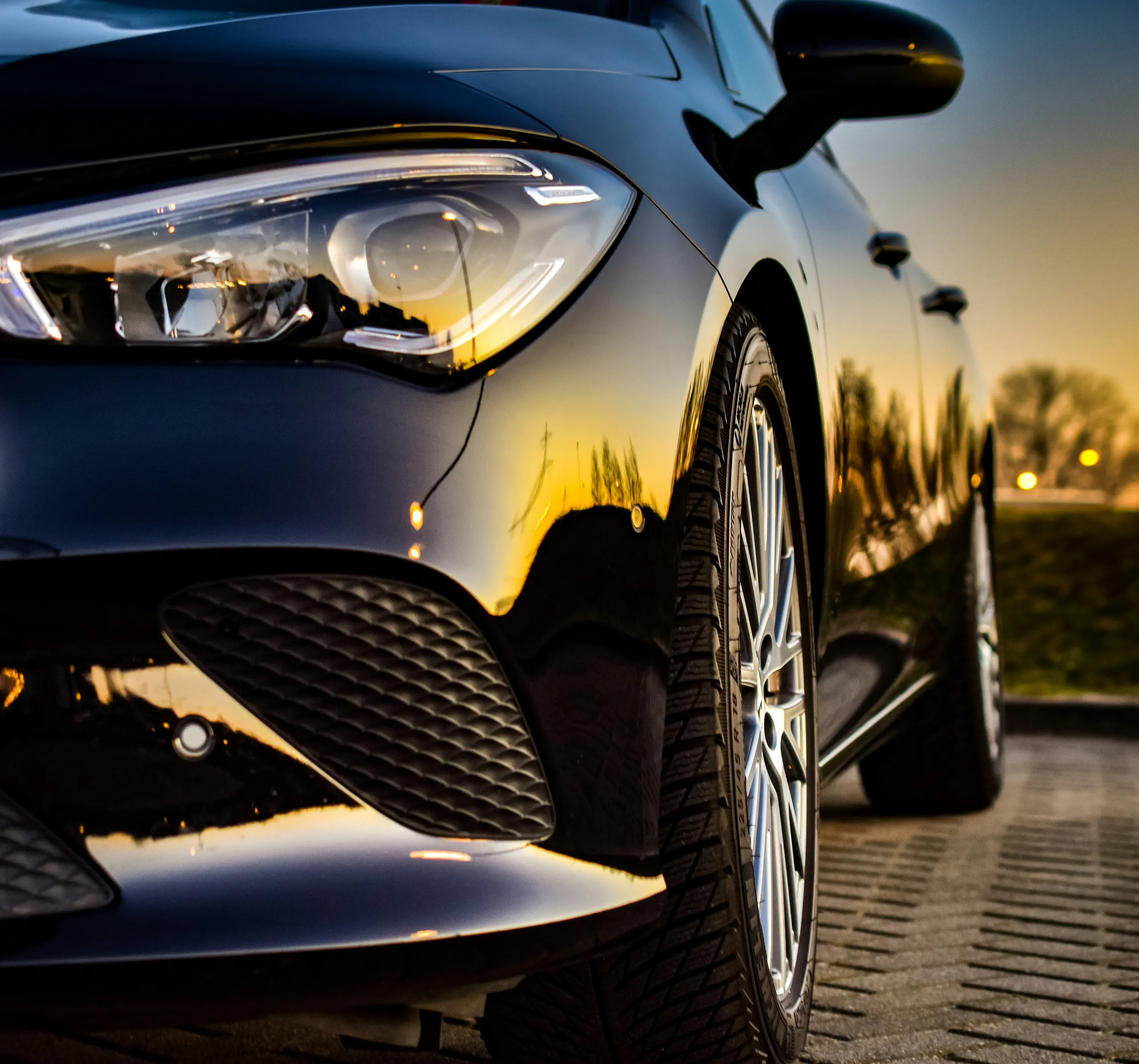 Ciemne auto z polerowanym lakierem o zachodzie słońca